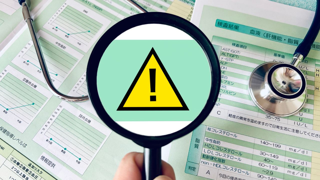 健康診断の結果票と警告マーク。血液検査で高コレステロールが出た場合は、再検査や生活習慣の見直しが必要なケースも