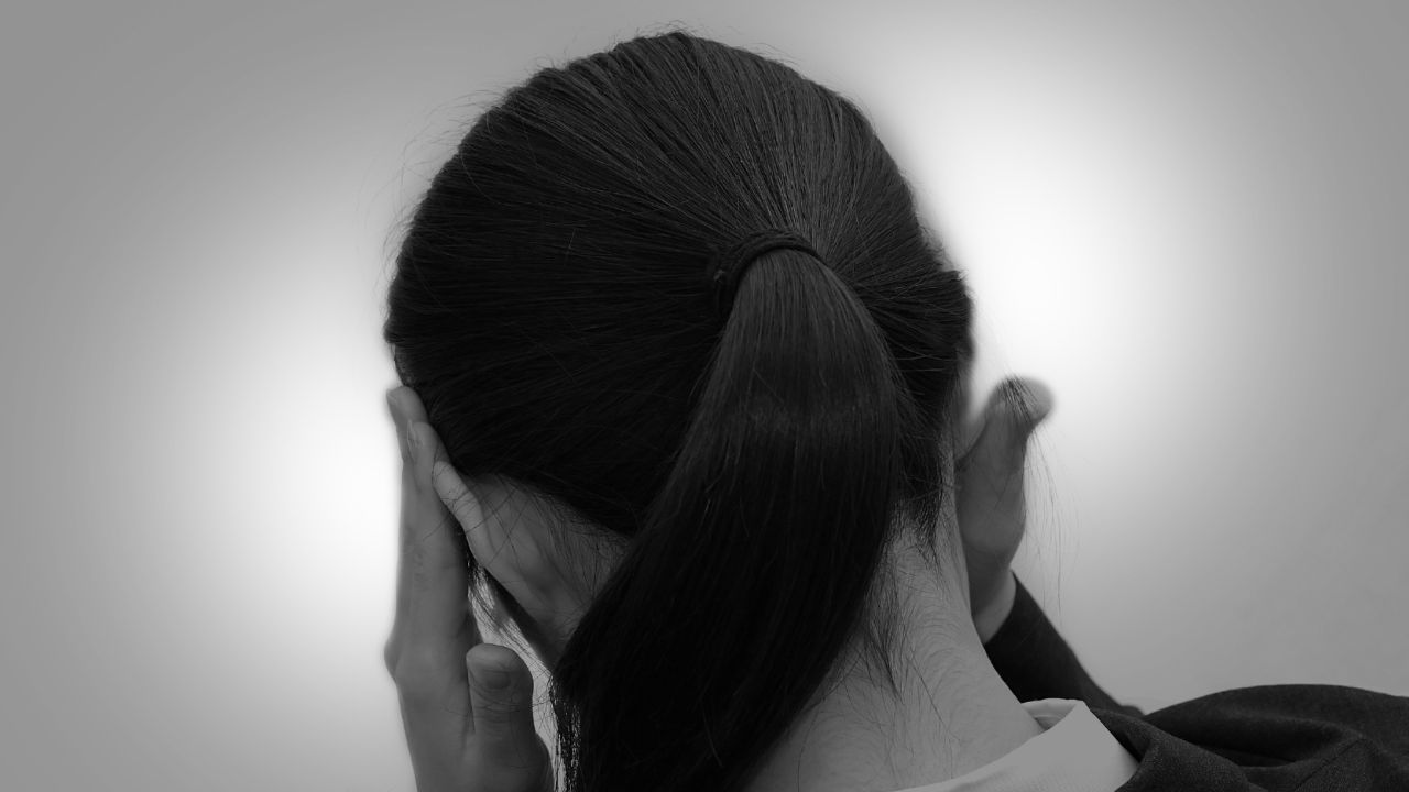 血液検査の結果に不安を感じてうつむく女性のシルエット。貧血が精神面にも影響を与えることを示唆
