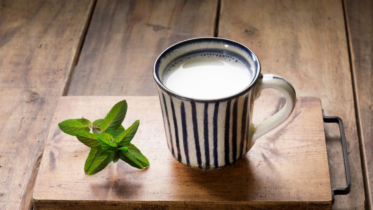 テーブルに置かれた牛乳のコップ。鉄分吸収を妨げる成分を含む牛乳は、摂取量に注意しないと牛乳貧血の原因になり得る