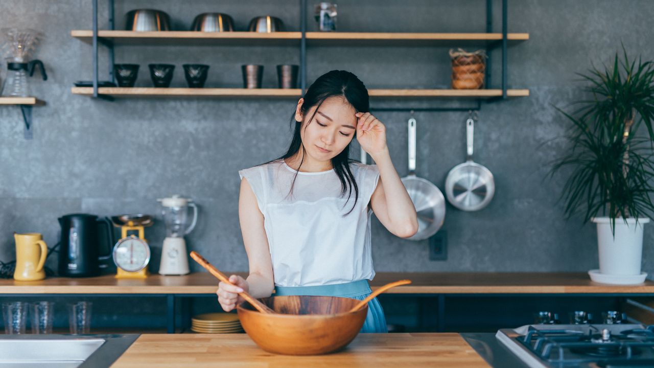食事で貧血を改善したいと考える女性が献立に悩む様子。鉄分を含む食べ物をどう取り入れるかが日常の課題