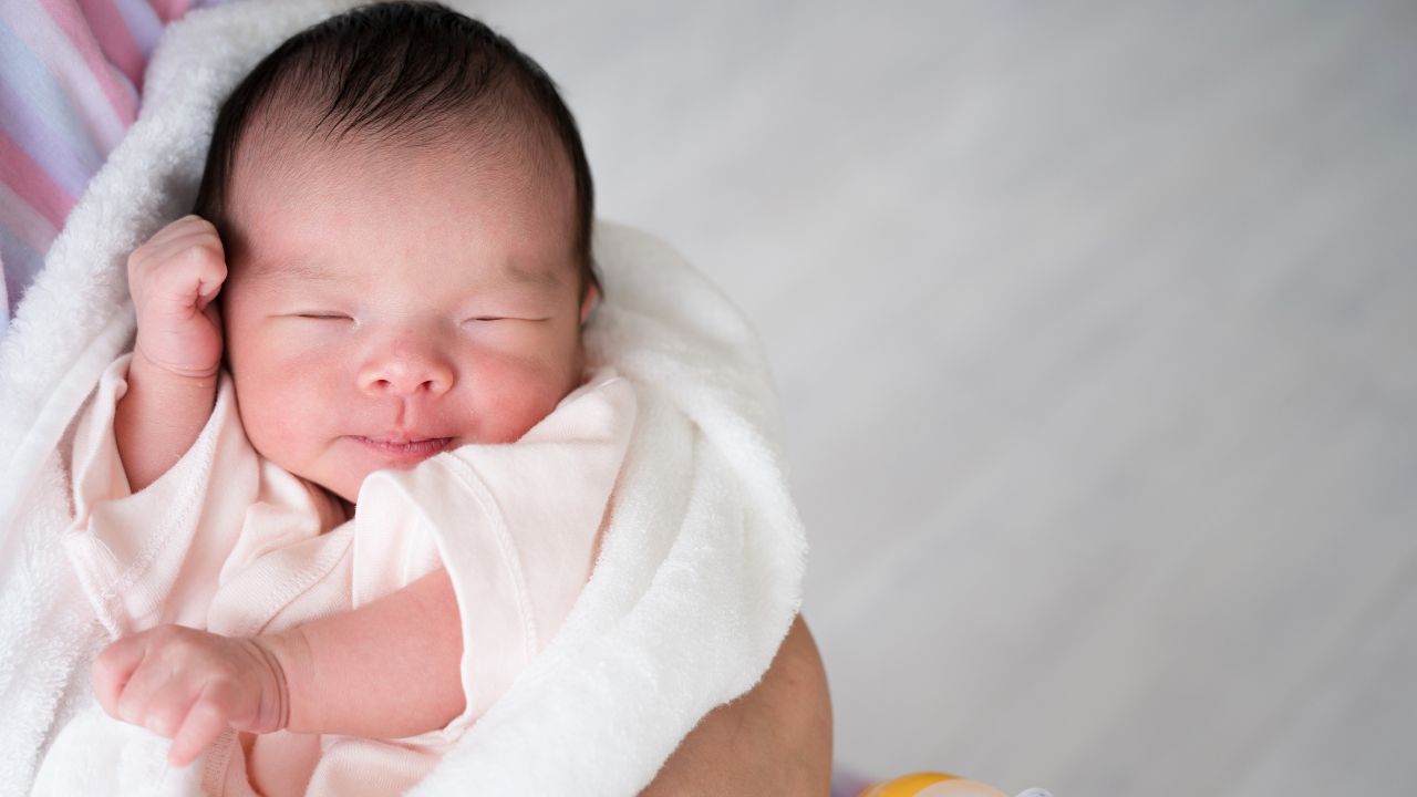 タオルに包まれて安心して眠る新生児。生後間もない赤ちゃんの鉄分補給は成長に欠かせない要素