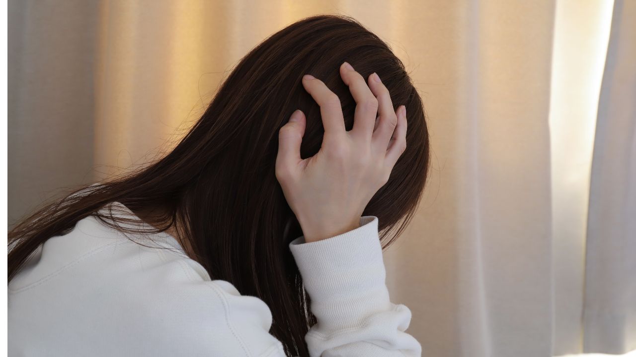 体調不良に悩む女性。鉄欠乏性貧血の原因による疲労感やめまいを訴えるシーン